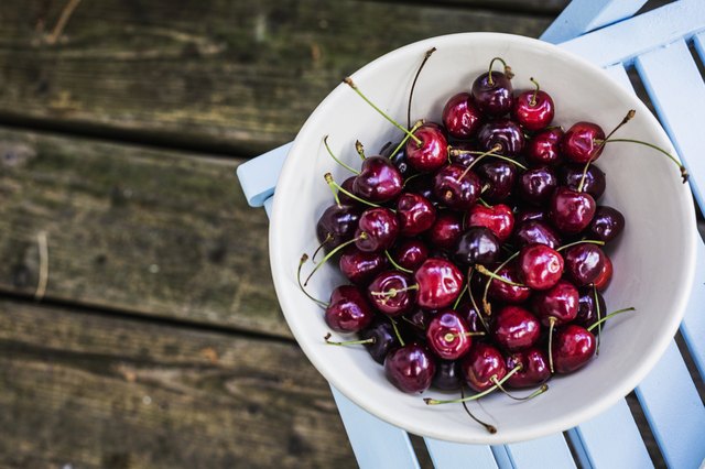 Bowl of cherries on top of patio chair