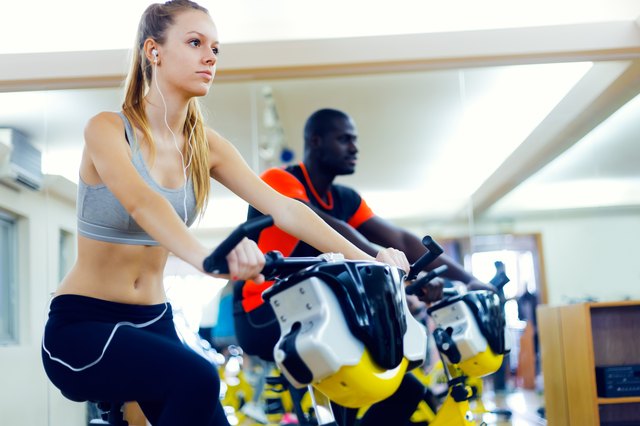 Young people with fitness bicycle in the gym.
