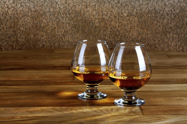 Two goblets of brandy on wooden old counter top