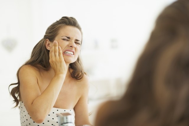Woman having toothache in bathroom