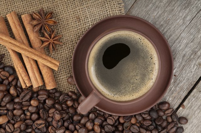 Coffee cup with spices on wooden table texture