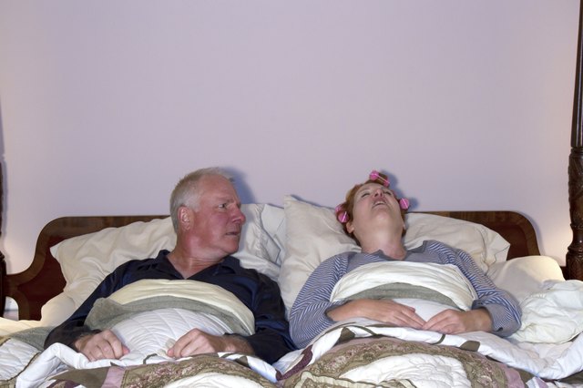 Man Looking Aghast at Wife in Bed