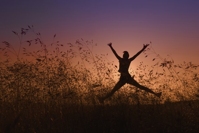 silhouette of girl jumping in a meadow
