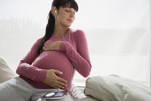 Pregnant woman listening to MP3 player