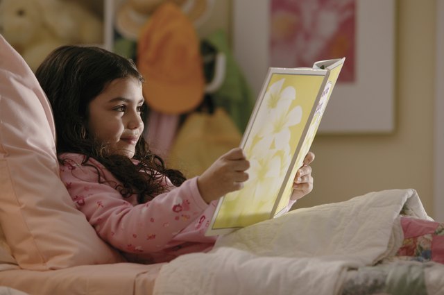Girl reading book in bed