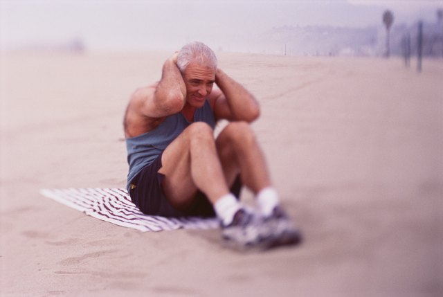 Man doing sit-ups on the beach