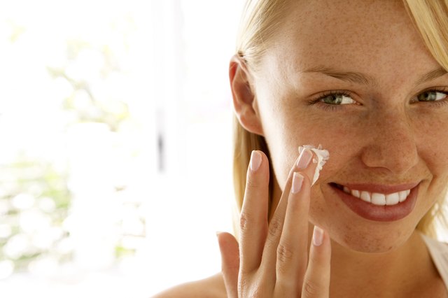 Woman applying skin cream