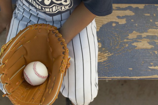 High angle view of a young boy wearing a baseball mitt holding a ball