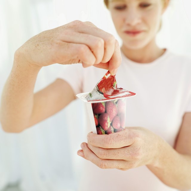 Woman opening a strawberry yoghurt
