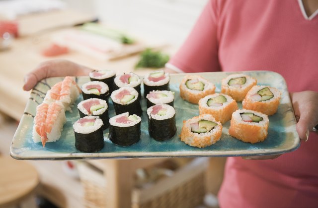 Close up of woman holding tray of sushi