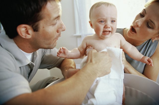 Close-up of parents giving their son a bath