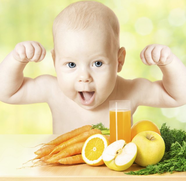 Sprong baby with raised hands, fresh fruits, vegetables, juice glass