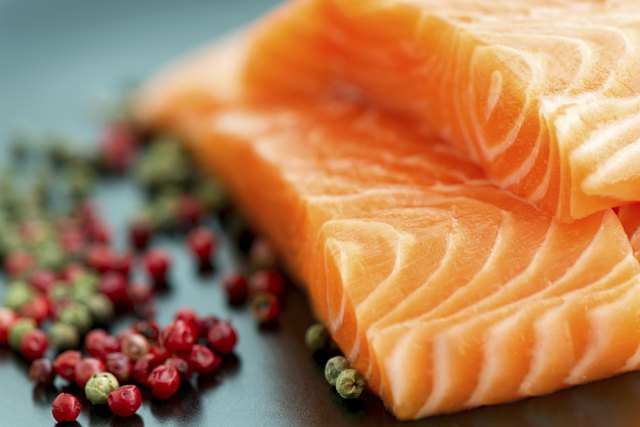 Raw salmon ready to cook close up on black surface