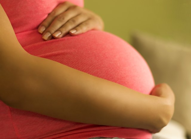 Pregnant woman embracing her belly