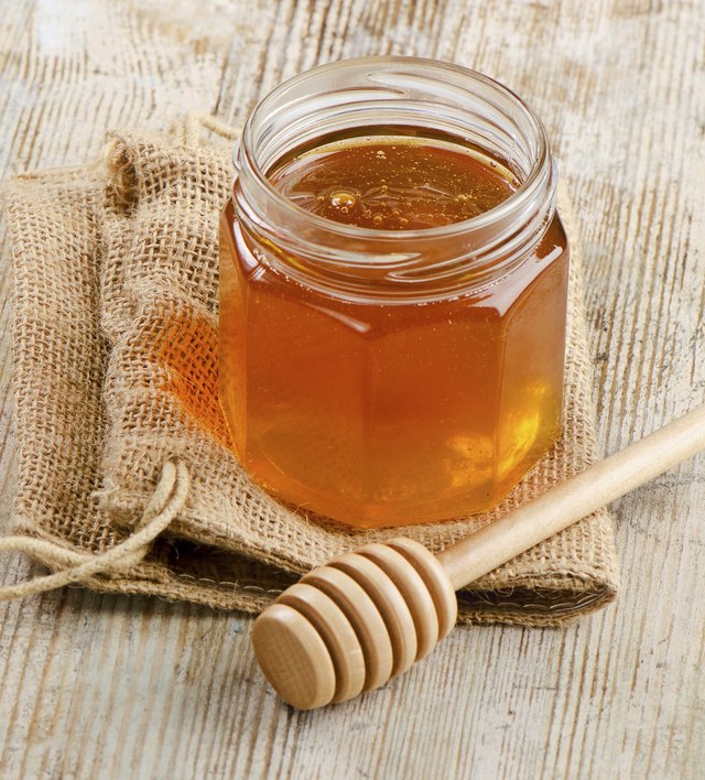 Jar of honey with wooden stick
