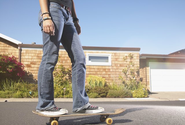 Low section view of a teenage girl skateboarding on the street