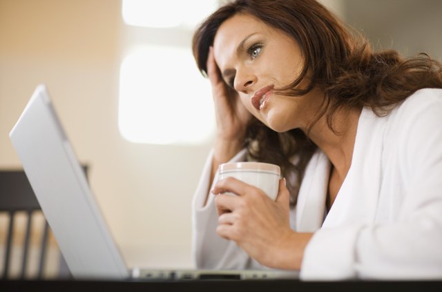Distraught woman working at home with laptop computer
