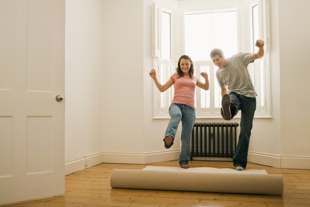 Couple unrolling carpet