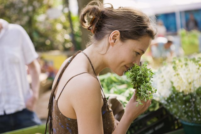 Woman smelling herbs at outdoor market