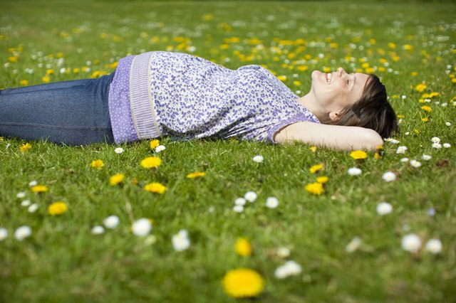 Pregnant woman lying on grass
