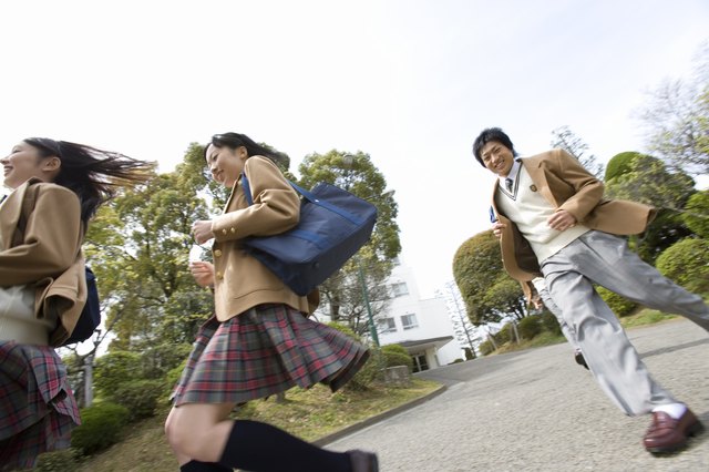 Three high school students running, low angle view, Japan