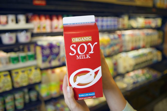 Person holding carton of soy milk