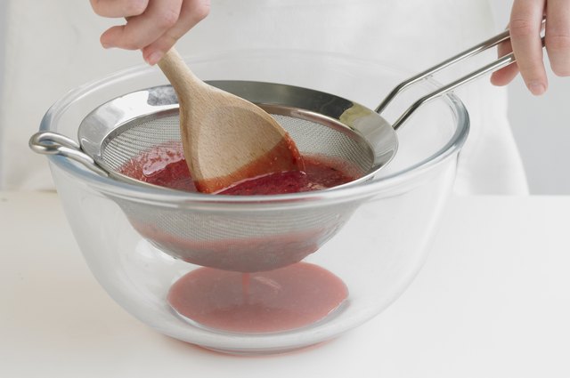 Straining blended fruit, close up