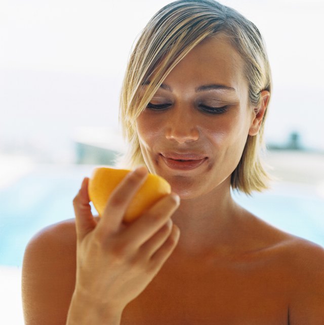 view of a young woman eating a grapefruit