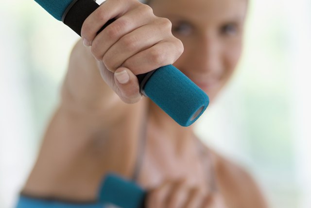Young woman using hand weight, close-up