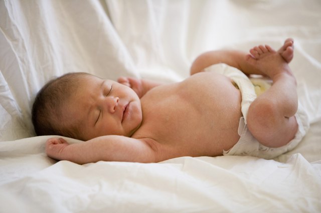 Newborn baby lying on bed