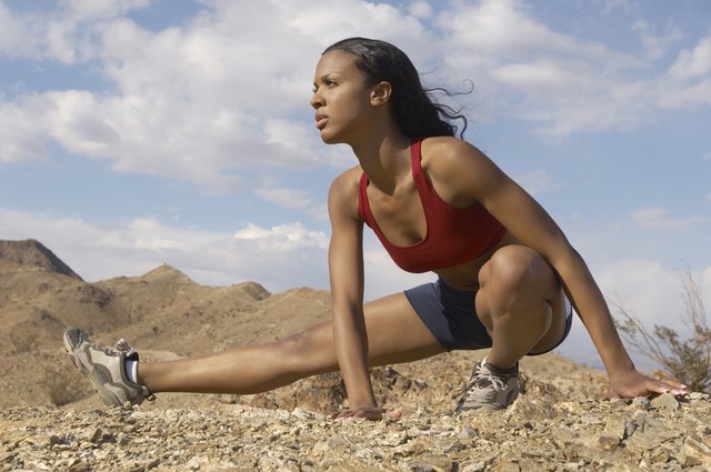 Female jogger stretching in mountains
