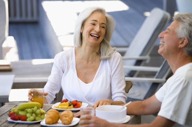 Couple laughing by plates of fruit