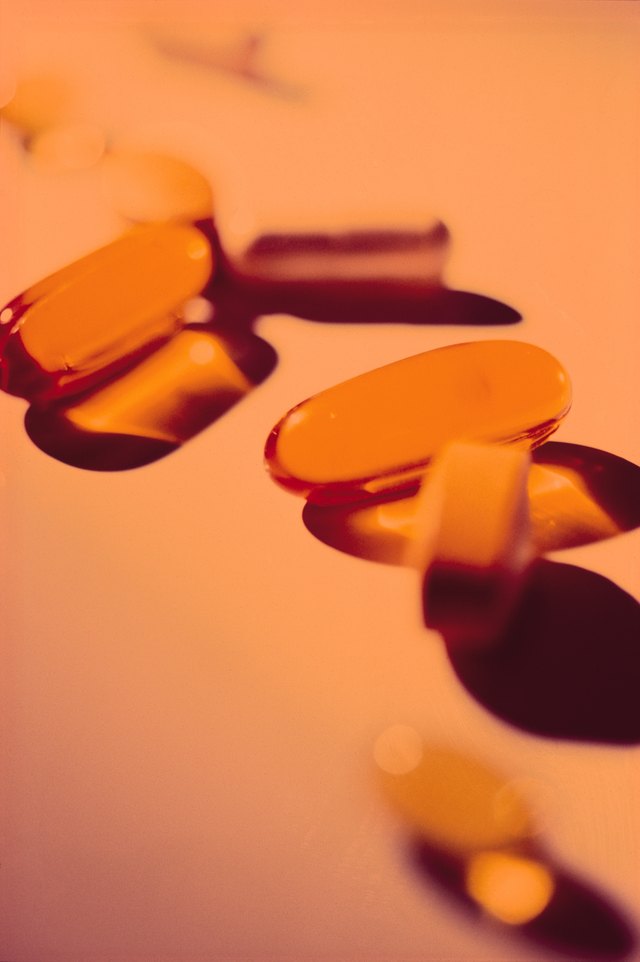 orange pills and gel caps rest on an orange background