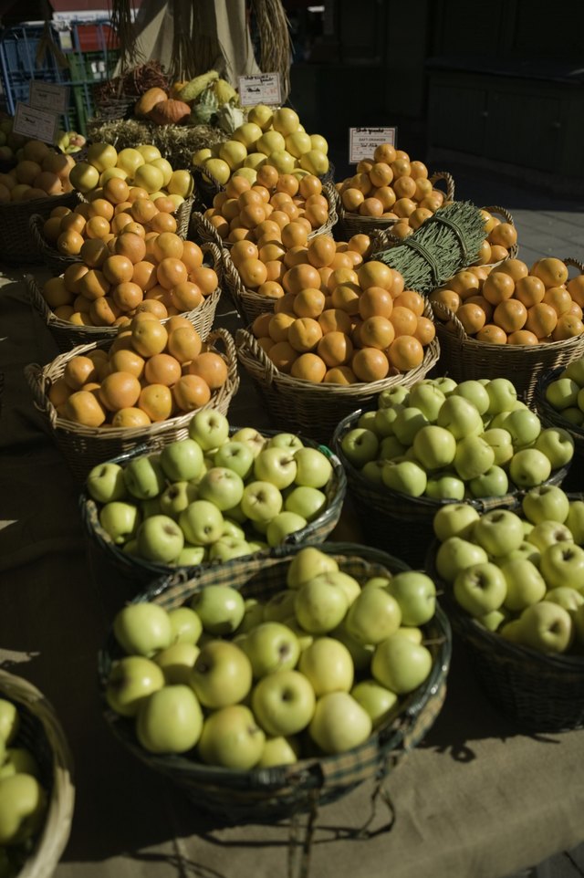 Baskets with oranges and apples on display at outdoor market