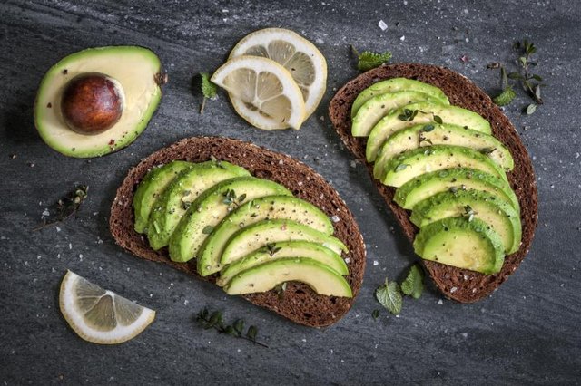 Avocado sandwich on dark rye bread made with fresh sliced avocados.