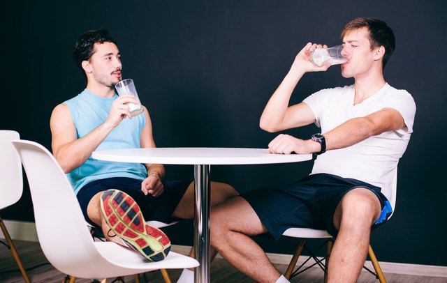 Young man drinking protein shake after training in health club