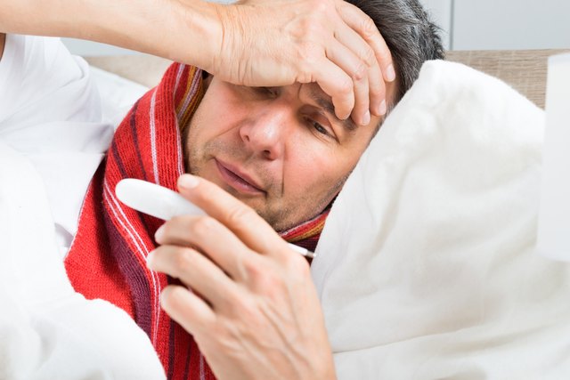 Mature Sick Man Holding A Thermometer