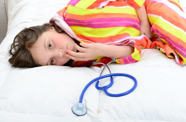 little girl in her bed has a stomachache