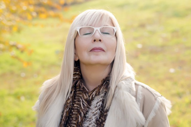 Portrait of a relaxed autumn mature woman breathing deep