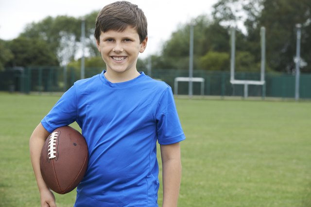 Portrait Of Boy Holding Ball On School Football Pitch