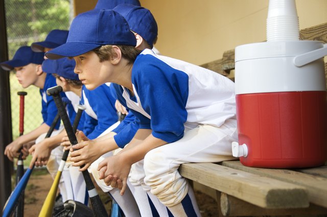 Young baseball players sitting in dugout