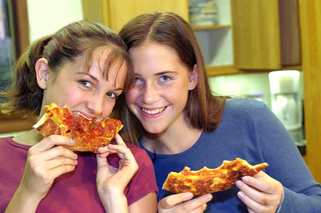 Teenage girls eating pizza