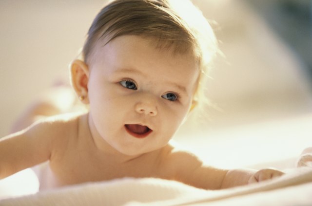 Close-up of a baby girl lying on a bed