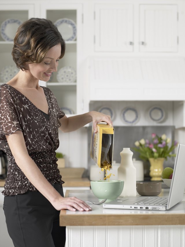 Mid adult woman pouring breakfast cereals
