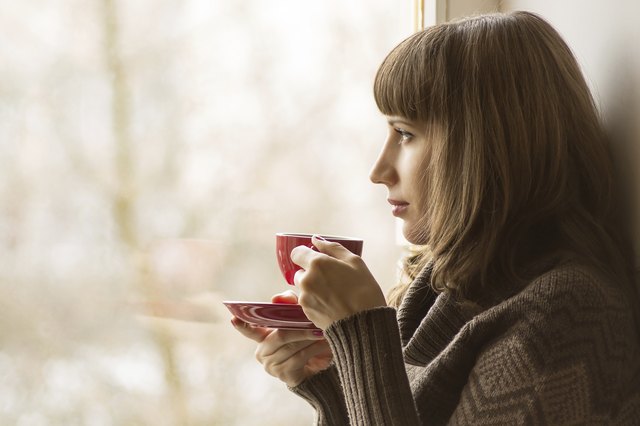 Beautiful girl drinking Coffee or Tea near Window