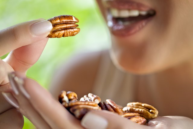 Woman with handful of pecans