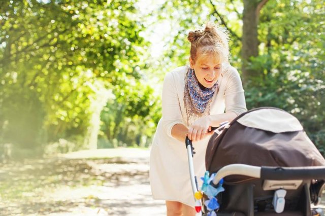 mother walking with baby in stroller