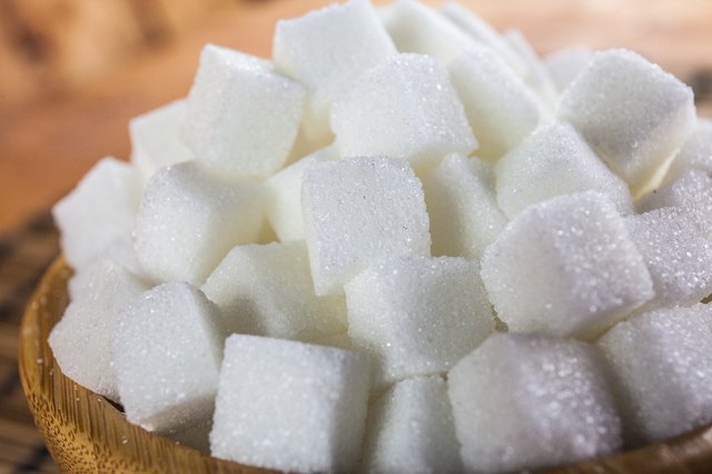 Pile of Sugar Cubes over Wooden Background