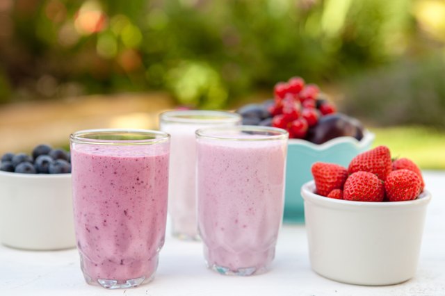 Three small glasses of smoothie on the white table