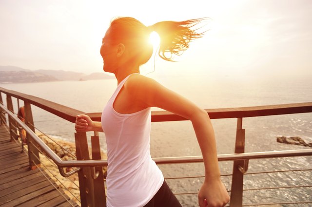 healthy lifestyle asian woman running at wooden trail seaside